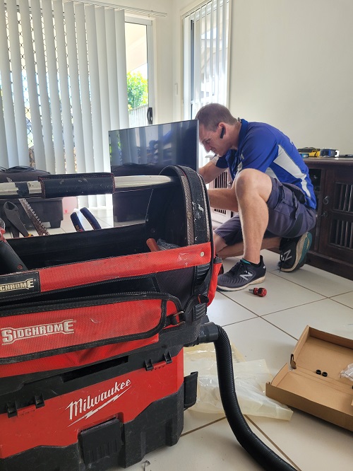 Technician assessing a damaged TV in a residential property