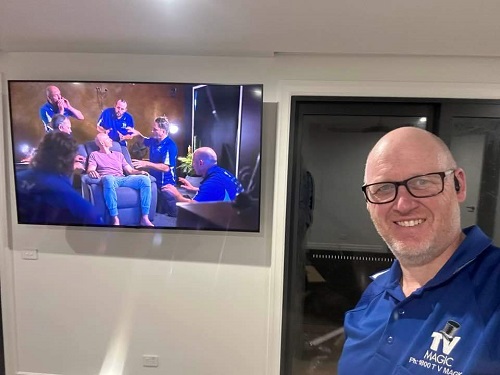 Technician in front of a TV he installed