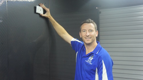 Jim holding a new TV Point up to the wall