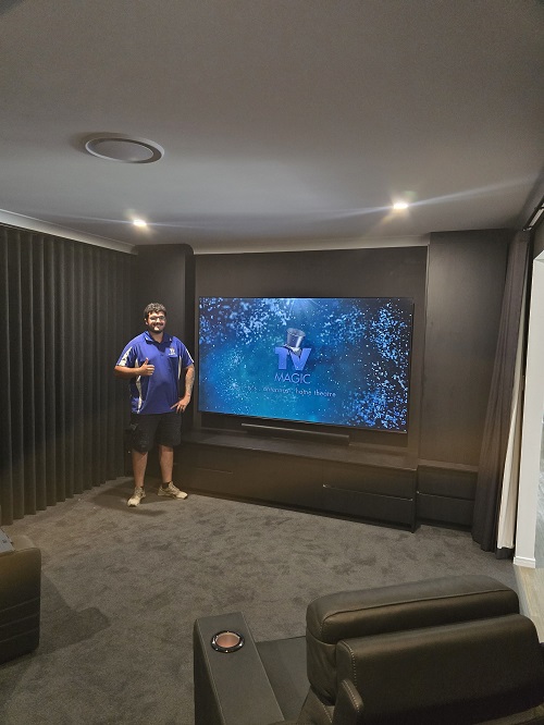 Technician in a home cinema he installed in Doonside