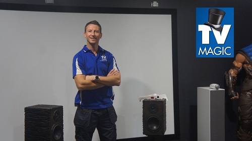 Jim with various home theatre equipment in front of a projector screen