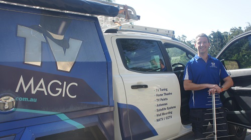 Technician Jim, standing by his vehicle with an antenna in hand.