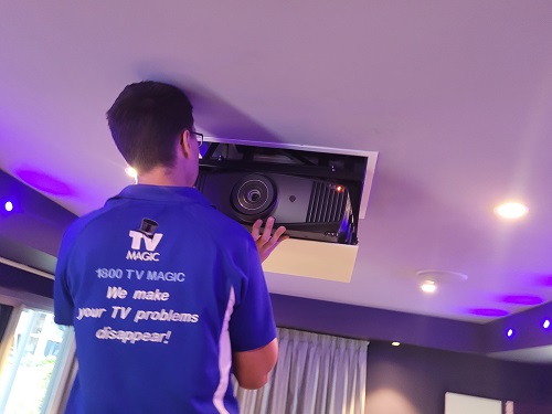 technician installing an in-ceiling motorised projector