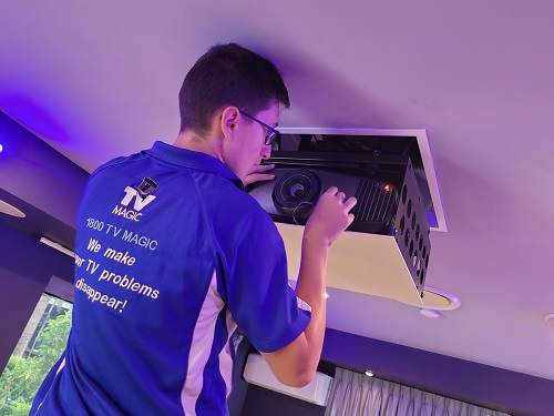 technician installing an in-ceiling motorised projector