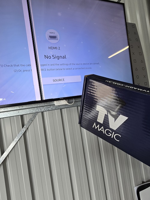 A broken TV screen with a TV Magic wall bracket in front of it.