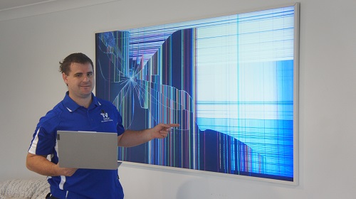 Technician with a severely damaged TV