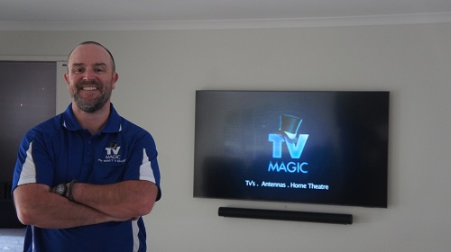 a technician with a wall mounted TV behind him
