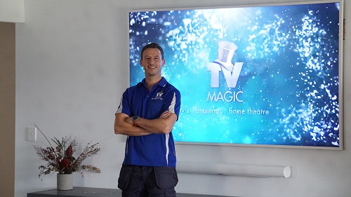 technician with a modern TV setup with wall mounted sound bar