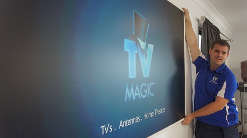 Technician wall mounting a TV