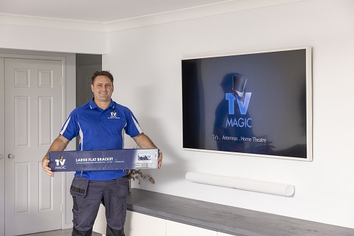 Wall mounted TV by TV Magic. Technician holding TV Magic wall bracket