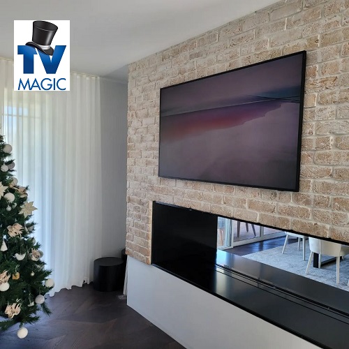 TV wall mounted over a recess with a christmas tree in left corner