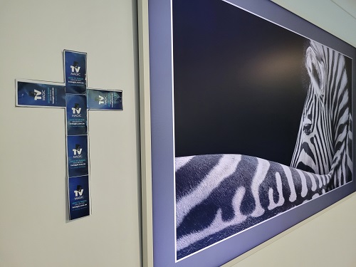 A wall mounted TV with a cross next to it made from TV Magic stickers