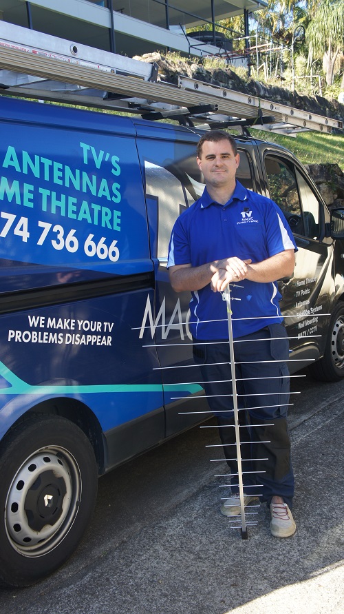 Technician standing next to his van with an antenna