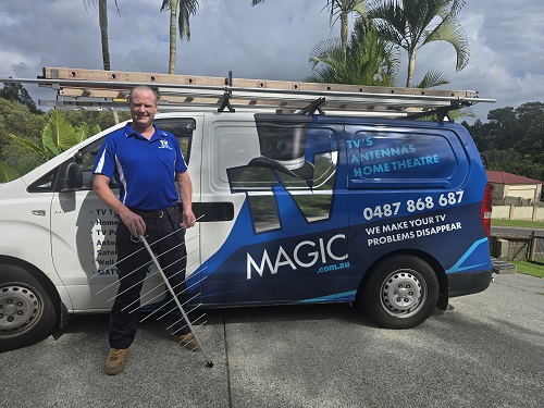 Technician Ben standing next to his van holding an antenna.