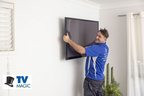 Technician installing a TV. Logo in bottom left corner.