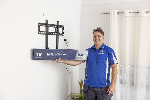 Technician with a TV Magic wall mounting bracket.