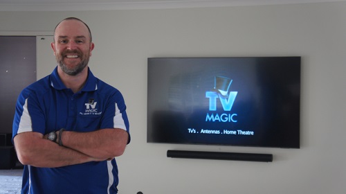 a technician in front of a wall mounted tv